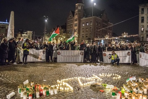 Ratusan orang menyalakan lilin serta kibarkan bendera Palestina saat unjuk rasa mendukung Gaza, pada 24 Desember 2023 pada Malam Natal di Amsterdam, Belanda. Foto: Mouneb Taim / Anadolu