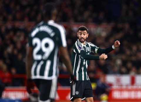 Bruno Fernandes komunikasi dengan Aaron Wan-Bissaka saat laga Nottingham Forest vs Manchester United dalam lanjutan Liga Inggris di Stadion City Ground pada Minggu (31/12) dini hari WIB. Foto: Action Images via Reuters/Lee Smith