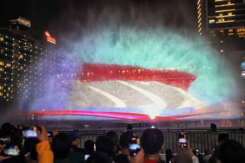 Warga menyaksikan water screen di perayaan malam tahun baru di Bundaran HI, Jakarta, Minggu (31/12/2023). Foto: Iqbal Firdaus/kumparan