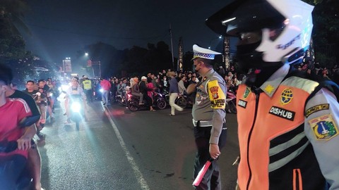 Polisi mengatur lalu lintai usai warga membubarkan diri setelah merayakan tahun baru di TMII. Foto: Twitter/@TMCPoldaMetro