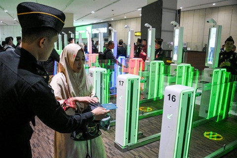 Petugas mengarahkan penumpang pesawat untuk memindai paspor dan pengenalan wajah di pintu otomatis (autogate) pemeriksaan imigrasi, Terminal 3 Bandara Internasional Soekarno Hatta, Tangerang, Banten, Rabu (3/1/2024). Foto: Sulthony Hasanuddin/ANTARA FOTO 
