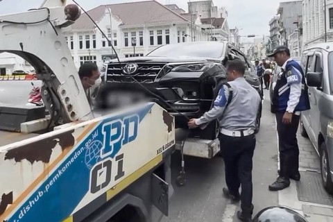 Mobil diangkut akibat parkir liar di atas trotoar yang baru selesai dikerjakan oleh Pemerintah Kota Medan. Foto: Instagram/@bobbynst