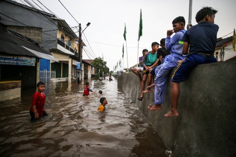 Sejumlah anak bermain saat terjadi banjir di Perumahan Pondok Maharta, Tangerang Selatan, Banten, Sabtu (6/1/2024). Foto: Rivan Awal Lingga/ANTARA FOTO