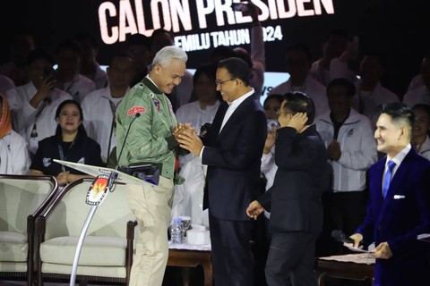 Calon presiden nomor urut 03 Ganjar Pranowo berbincang dengan capres nomor 01 Anies Baswedan saat debat ketiga Pilpres 2024 di Istora Senayan, Kompleks GBK, Jakarta Pusat, Minggu (7/1/2024). Foto: Iqbal Firdaus/kumparan