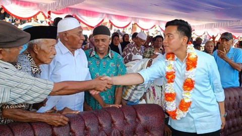 Cawapres Gibran Rakabuming Raka dan istrinya, Selvi Ananda saat bagi-bagi susu di Lapangan Desa Liang, Salahutu, Maluku Tengah, Maluku, Senin (8/1).  Foto: Zamachsyari/kumparan