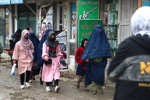 Wanita Afghanistan berjalan di sepanjang jalan di sebuah pasar di distrik Fayzabad di provinsi Badakhshan pada 12 Desember 2023. Foto: OMER ABRAR/AFP