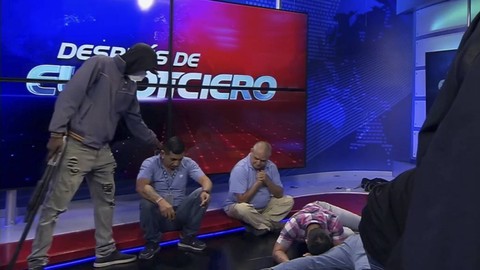 Tangkapan layar video langsung dari jaringan TC Television menunjukkan orang bertopeng dan bersenjata berdiri di depan wartawan selama siaran langsung, di Guayaquil, Ekuador, Selasa, 9 Januari 2024. Foto: Jaringan Televisi TC melalui AP