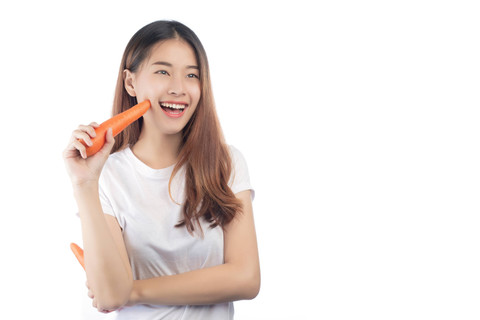 Ilustrasi perempuan makan wortel. Foto: 271 EAK MOTO/Shutterstock