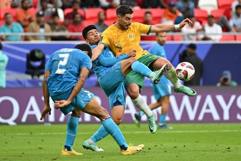 Bruno Fornaroli (kanan) melepaskan tembakan dalam pertandingan Grup B Piala Asia 2023 antara Australia vs India di Stadion Ahmad bin Ali, Al Rayyan, Qatar, pada Sabtu (13/1). Foto: Hector Retamal / AFP
