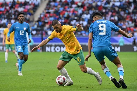 Aziz Behich (tengah) menggiring bola dalam pertandingan Grup B Piala Asia 2023 antara Australia vs India di Stadion Ahmad bin Ali, Al Rayyan, Qatar, pada Sabtu (13/1). Foto: Hector Retamal / AFP
