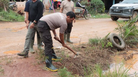 Kapolres Sekadau membuat saluran air saat gotong royong bersama warga memperbaiki jalan rusak. Foto: Dok. Polres Sekadau