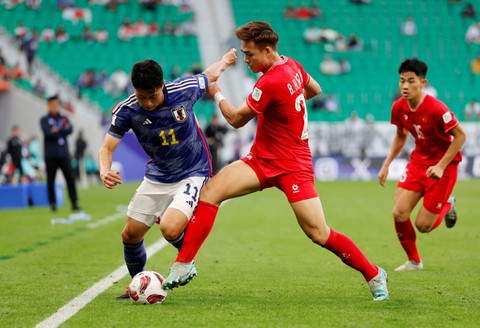Mao Hosoya dari Jepang beraksi dengan Bui Hoang Viet Anh saat pertandingan Piala Asia AFC di Stadion Al Thumama, Doha, Qatar. Foto: Molly Darlington/Reuters