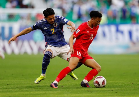Yukinari Sugawara dari Jepang duel dengan Nguyen Thai Son dari Vietnam saat pertandingan Piala Asia AFC di Stadion Al Thumama, Doha, Qatar. Foto: Thaier Al-Sudani/Reuters