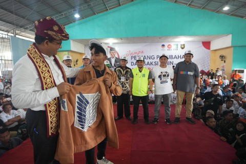 Capres nomor urut 01 Anies Baswedan disematkan jaket Attack on Titan oleh perwakilan gen Z dalam acara Jumpa Saksi AMIN di GOR Podomoro Natar, Lampung Selatan, Minggu (14/1). Foto: Dok. Istimewa