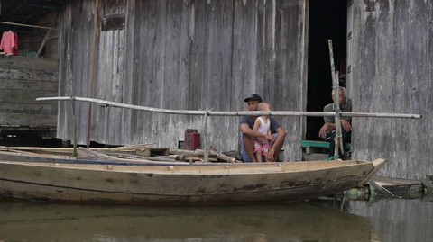 Seorang warga menunggu surutnya air yang merendam rumahnya akibat luapan air sungai yang memicu bencana banjir di Kabupaten Musi Banyuasin Sumatera Selatan, Sabtu (20/1) Foto: urban id