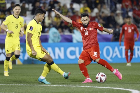 Bek Malaysia Shahrul Saad berebut bola melawan gelandang Bahrain Komail al-Aswad selama pertandingan sepak bola Grup E Piala Asia AFC Qatar 2023 antara Bahrain dan Malaysia di Stadion Jassim bin Hamad di Doha pada 20 Januari 2024. Foto: KARIM JAAFAR / AFP