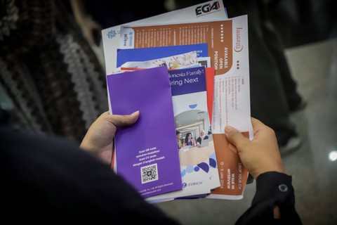 BROSUR LOKER -  Pencari kerja mengumpulkan sejumlah brosur lowongan kerja. Foto: Jamal Ramadhan/kumparan