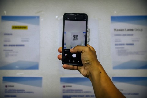 SCAN QR CODE -  Pencari kerja memindai QR Code untuk melihat lowongan pekerjaan. Foto: Jamal Ramadhan/kumparan