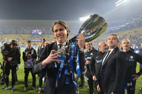 Pelatih Inter Milan asal Italia Simone Inzaghi membawa trofi usai memenangi pertandingan sepak bola final Piala Super Italia antara Napoli dan Inter Milan di Stadion Al-Awwal Park di Riyadh, pada Senin (22/1/2024). Foto: AFP