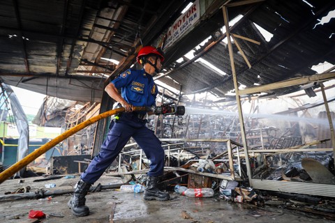 Petugas pemadam kebakaran menyelesaikan proses pendinginan lokasi kebakaran di salah satu ruko di Pasar Mobil, Kemayoran, Jakarta, Rabu (24/1/2024). Foto: Iqbal Firdaus/kumparan
