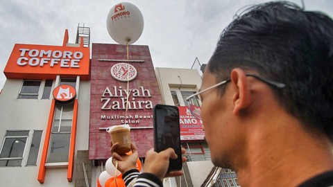 Salah satu pengunjung yang mengabadikan salah satu produk kopi di depan gedung Tomoro coffee shop Palembang, Sabtu (27/1) Foto: ary priyanto/urban id