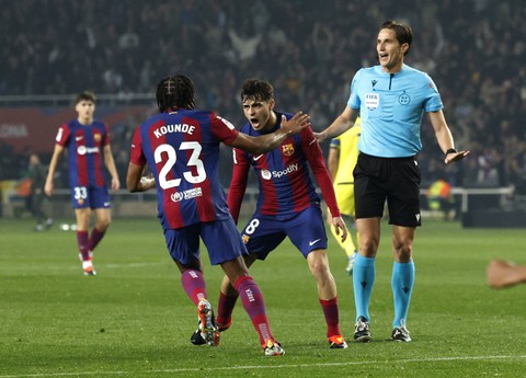 Selebrasi Jules Kounde dan Pedri Gonzalez saat laga Barcelona vs Villarreal dalam pekan ke-22 Liga Spanyol 2023/24 di Estadi Olimpic Lluis Companys pada Minggu (28/1/2024) dini hari WIB. Foto: REUTERS/Albert Gea