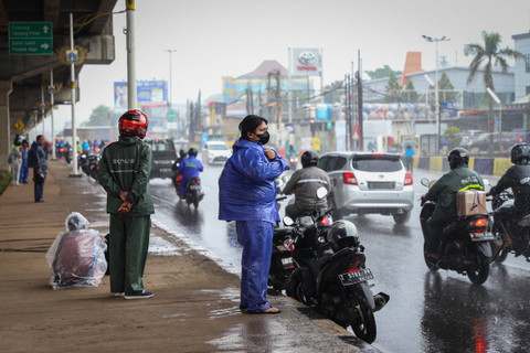 Pengendara kendaraan berteduh disaat hujan di Jalan Laksamana Malahayati, Cipinang, Jakarta, Senin (30/1). Foto: Iqbal Firdaus/kumparan
