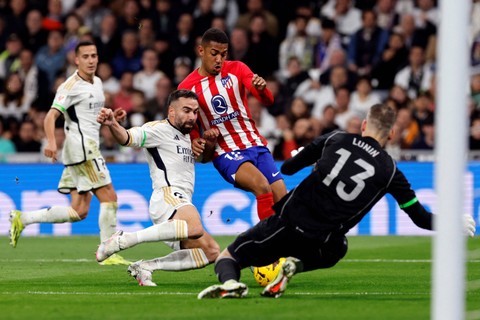 Pemain Real Madrid Dani Carvajal berebut bola dengan pemain Atletico Madrid Samuel Lino pada pertandingan Liga Spanyol di Santiago Bernabeu, Madrid, Minggu (4/2/2024). Foto: OSCAR DEL POZO / AFP