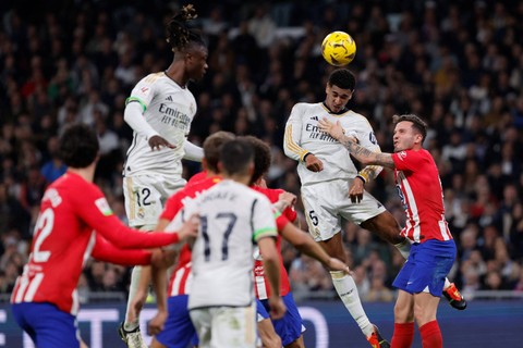 Pemain Real Madrid Jude Bellingham menyundul bola ke arah gawang Atletico Madrid pada pertandingan Liga Spanyol di Santiago Bernabeu, Madrid, Minggu (4/2/2024). Foto: OSCAR DEL POZO / AFP