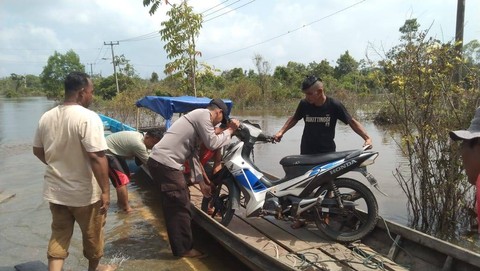  Personel Polsek Langgam bantu warga terjebak banjir dan tak dapat melintas. Foto: Dok. Istimewa