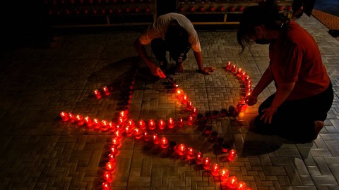 Dua orang warga etnis tiong hoa melakukan penyalaan lilin yang menjadi rangkaian kegiatan imlek di wihara Dharmakirti Palembang, Sabtu (10/2) Foto: ary priyanto/urban id