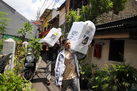 Petugas membawa kotak serta surat suara Pemilu 2024 ke dalam gang pemukiman padat penduduk di kawasan Petamburan, Kecamatan Tanah Abang Jakarta Pusat, Selasa (13/2/2024). Foto: Jamal Ramadhan/kumparan