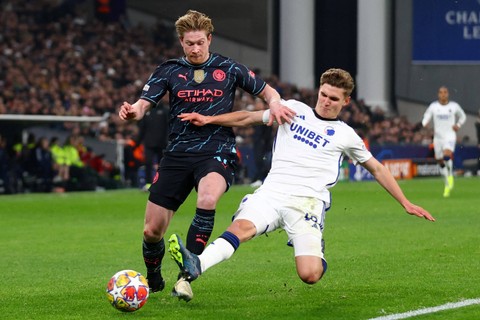 Pemain Manchester City Kevin De Bruyne berusaha melewati pemain FC Copenhagen Elias Jelert Kristensen pada pertandingan leg pertama Liga Champions di Parken Stadium, Kopenhagen, Denmark, Rabu (14/2/2024). Foto: Matthew Childs/REUTERS