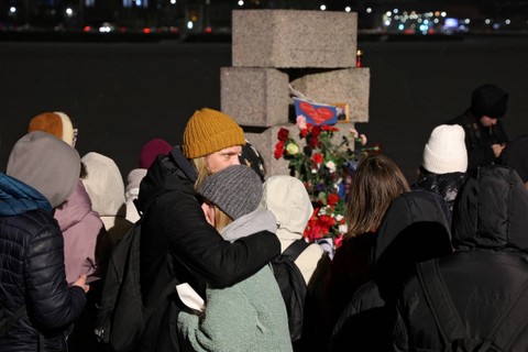 Orang-orang berkumpul di monumen korban penindasan politik setelah kematian pemimpin oposisi Rusia Alexei Navalny di Saint Petersburg, Rusia, Jumat (16/2/2024). Foto: Stringer/REUTERS