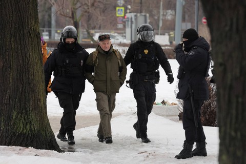 Petugas penegak hukum membawa seorang pria menjauh dari monumen Batu Solovetsky menuju para korban penindasan politik, tempat orang berkumpul untuk menghormati mengenang pemimpin oposisi Rusia Alexei Navalny, di Saint Petersburg, Rusia, Sabtu (17/2). Foto: STR/REUTERS