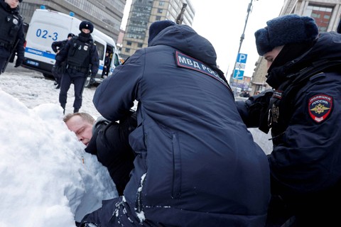 Petugas penegak hukum membawa seorang pria menjauh dari monumen Batu Solovetsky menuju para korban penindasan politik, tempat orang berkumpul untuk menghormati mengenang pemimpin oposisi Rusia Alexei Navalny, di Saint Petersburg, Rusia, Sabtu (17/2). Foto: STR/REUTERS
