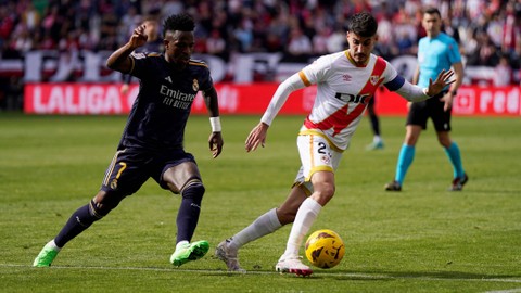 Vinicius Jr duel dengan Oscar Valentin saat laga Rayo Vallecano vs Real Madrid dalam pekan ke-25 Liga Spanyol 2023/24 di Campo de Futbol de Vallecas pada Minggu (18/2) malam WIB. Foto: REUTERS/Ana Beltran
