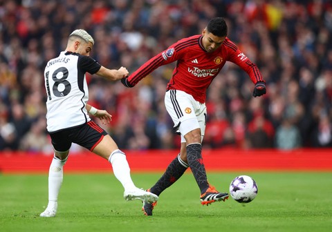 Casemiro dari Manchester United menendang bola dari penjagaan Andreas Pereira dari Fulham di Old Trafford, Manchester, Inggris, Sabtu (24/2). Foto: Reuters/Carl Recine