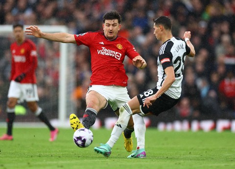 Harry Maguire dari Manchester United berusaha merebut bola dari Sasa Lukic dari Fulham. Foto: Reuters/Carl Recine