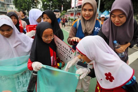 Sejumlah anak-anak yang tergabung dari sebuah komunitas mengumpulkan sampah di area Car Free Day (CFD) Bundaran HI, Jakarta, Minggu (25/2/2024). Foto: Iqbal Firdaus/kumparan