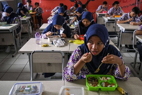 Sejumlah siswa menyantap makanan gratis saat simulasi program makan siang gratis di SMP Negeri 2 Curug, Kabupaten Tangerang, Banten, Kamis (29/2/2024). Foto: Sulthony Hasanuddin/Antara Foto
