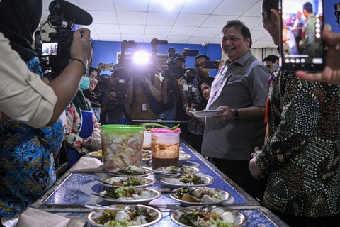 Menko Perekonomian Airlangga Hartarto mencicip makanan saat simulasi program makan siang gratis di SMP Negeri 2 Curug, Kabupaten Tangerang, Banten, Kamis (29/2/2024). Foto: Sulthony Hasanuddin/Antara Foto