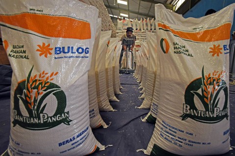 Pekerja menjahit karung berisi beras paket bantuan sosial pangan ukuran 10 kilogram di gudang Bulog Serang, Banten, Jumat (1/3/2024). Foto: ANTARA FOTO/Asep Fathulrahman