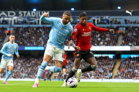 Pemain Manchester City Kyle Walker berebut bola dengan pemain Manchester United Marcus Rashford pada pertandingan Liga Inggris di Stadion Etihad, Manchester, Inggris, Minggu (3/3/2024). Foto: Carl Recine/REUTERS