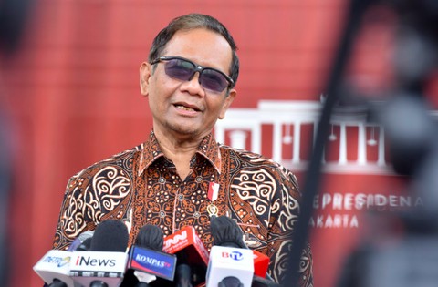 Menko Polhukam Mahfud memakai pita tanda jabatan menteri saat memberikan penjelasan kepada wartawan di Istana Presiden pada Rabu (12/10/2022). Foto: Dok. Humas Setkab/Jay