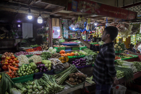 Pembeli menggunakan aplikasi Livin' Bank Mandiri untuk membayar dengan QRIS di pasar tradisional di Jakarta, Jumat (8/3/2024). Foto: Jamal Ramadhan/kumparan