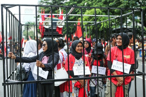 Sejumlah perempuan melakukan aksi dengan dikurung jeruji besi saat memperingati Hari Perempuan Internasional di kawasan Patung Kuda, Jakarta, Jumat (8/3/2024). Foto: Asprilla Dwi Adha/Antara Foto
