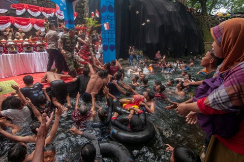 Sejumlah pengunjung berebut gunungan apem saat prosesi Tradisi Padusan Merti Rogo di Obyek Mata Air Cokro, Tulung, Klaten, Jawa Tengah, Minggu (10/3/2024). Foto: Aloyisus Jarot Nugroho/Antara Foto