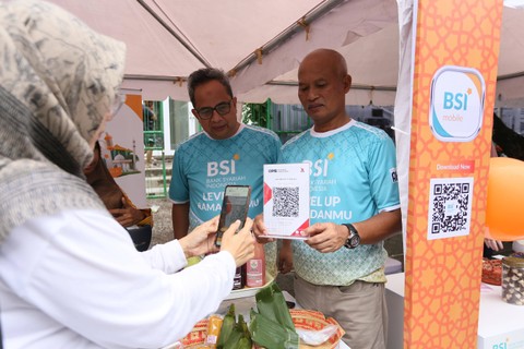 Direktur Retail Banking BSI Ngatari (tengah) menyapa pengunjung masjid dan menunjukkan QRIS untuk pembayaran umkm di area masjid. Selama ramadhan, BSI mendorong digitalisasi umkm melalui optimalisasi layanan masjid untuk meningkatkan ekosistem halal. Foto: dok. BSI 