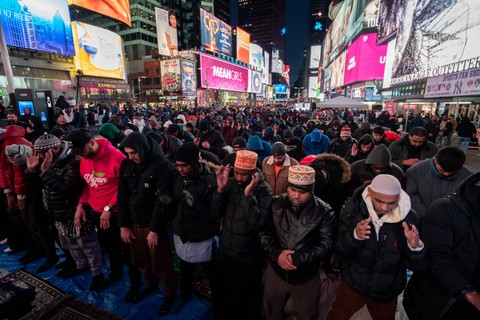 Warga muslim melaksanakan salat tarawih di Times Square, New York City, Amerika Serikat, Minggu (10/3/2024). Foto: Adam Gray / AFP